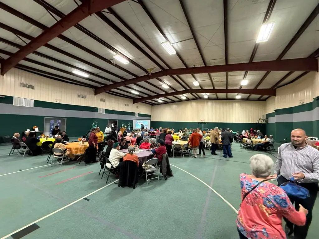 Group dinner at round tables in the Thompson Family Life Center gym