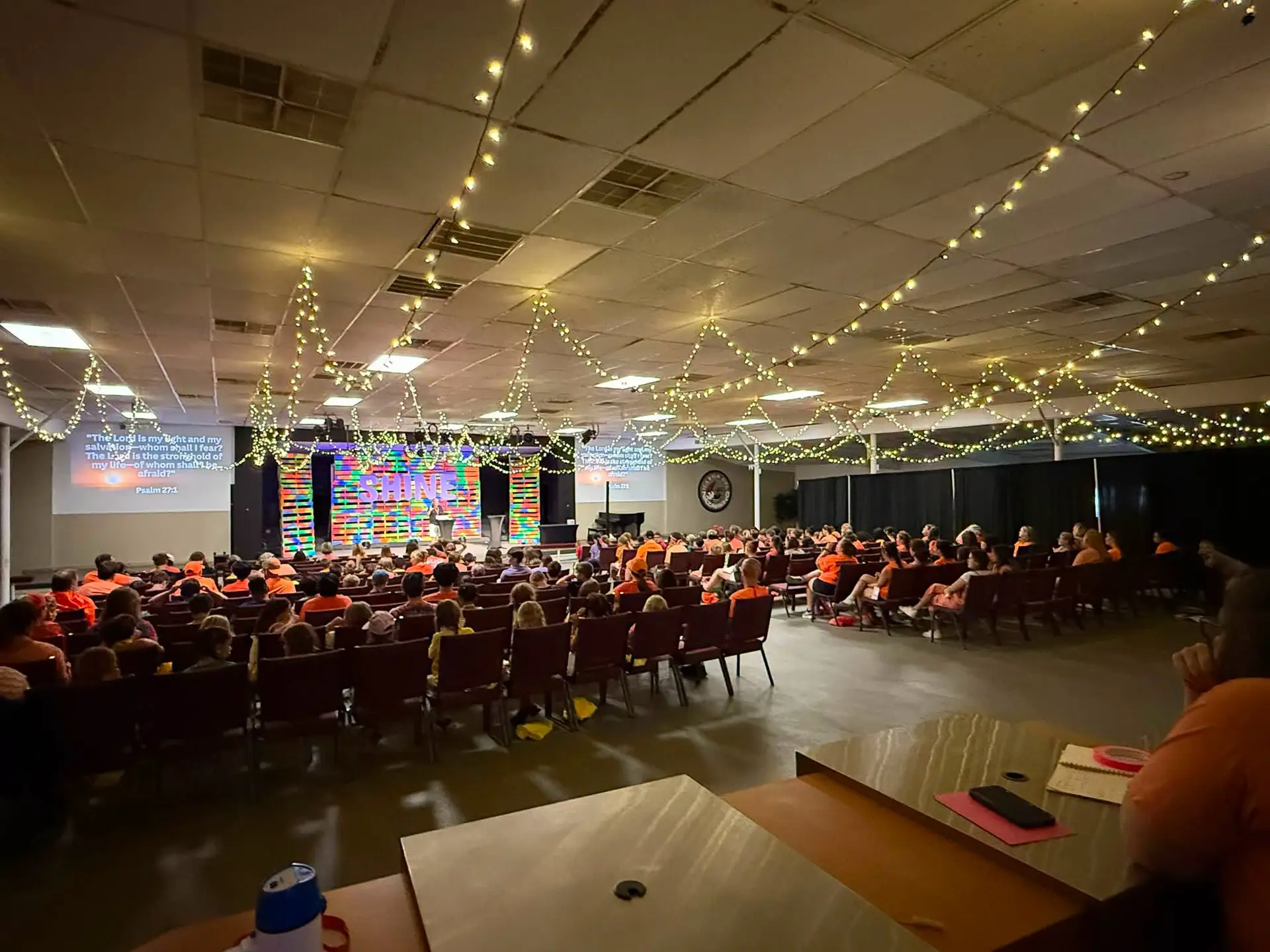 Evening event under string lights in a packed hall