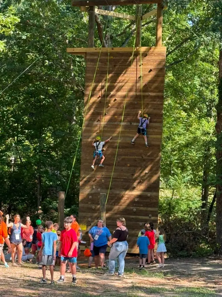 Kids cheering on a camper at the climbing wall